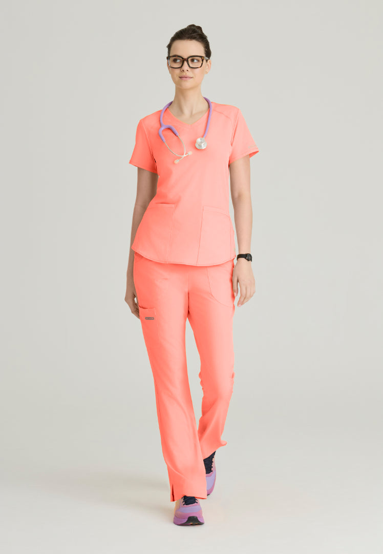 Woman wearing a Skechers Coral Fizz medical scrub set (SK101 scrub top and SK201 scrub pant) on a plain background