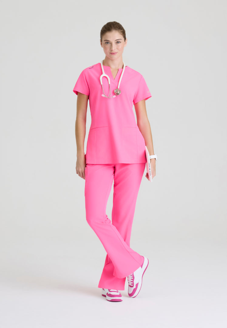 Woman wearing a Skechers Passion Pink medical scrub set (SKT259 scrub shirt and SKP623 scrub pant) on a white background