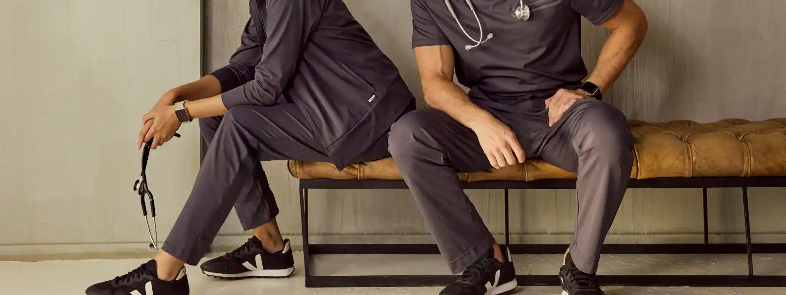 A group of folded medical scrub pants in various styles, including jogger, cargo, and straight leg, neatly displayed on a clean surface.