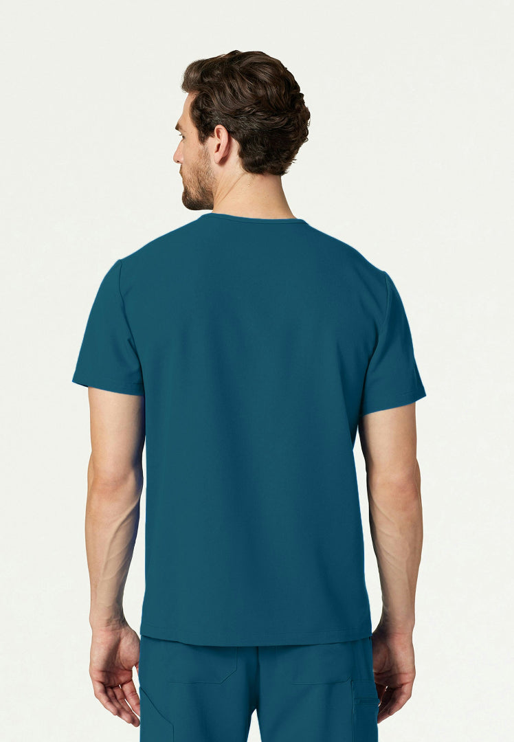 Back view of a man wearing a caribbean blue Jaanuu Platt scrub top and Jannuu scrub pants on a white background