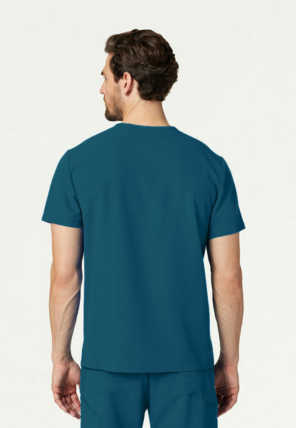 Back view of a man wearing a caribbean blue Jaanuu Platt scrub top and Jannuu scrub pants on a white background