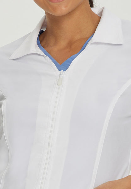 Close-up of a person wearing a White Cross zip-up 2417 lab coat over a blue shirt.