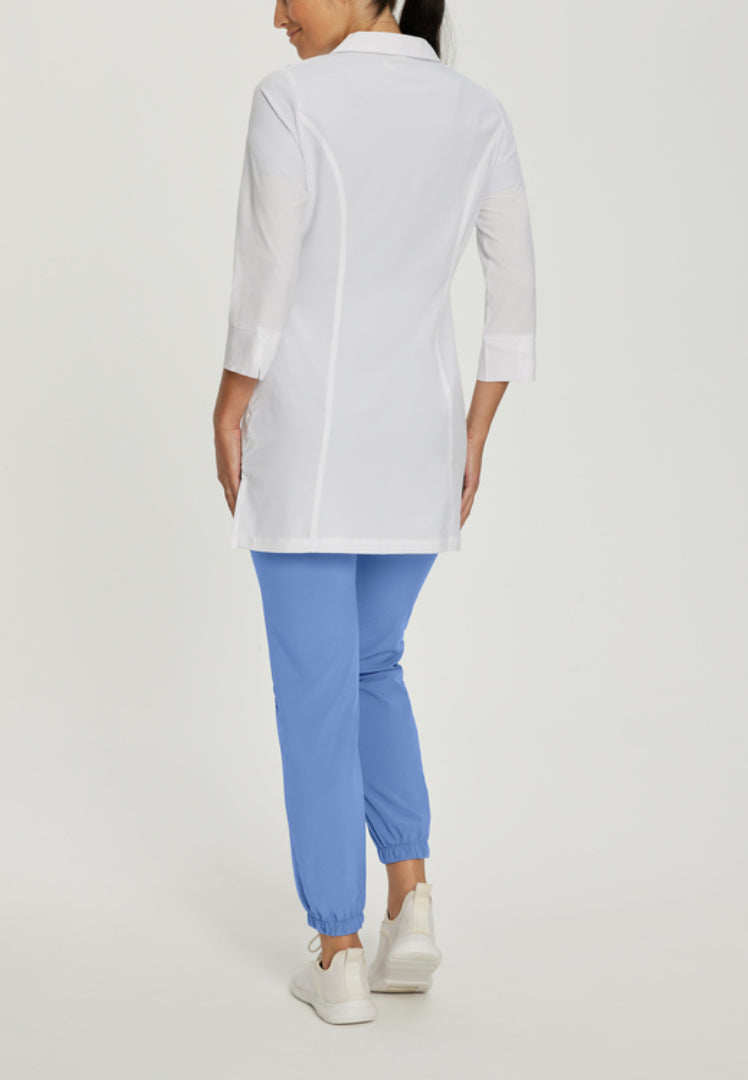 Back view of a person wearing a White Cross 2417 lab coat and blue pants on a light gray background