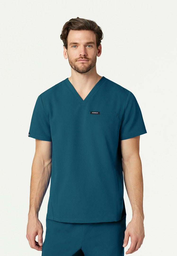 Man wearing a caribbean blue Jaanuu Platt V-neck scrub shirt on a white background