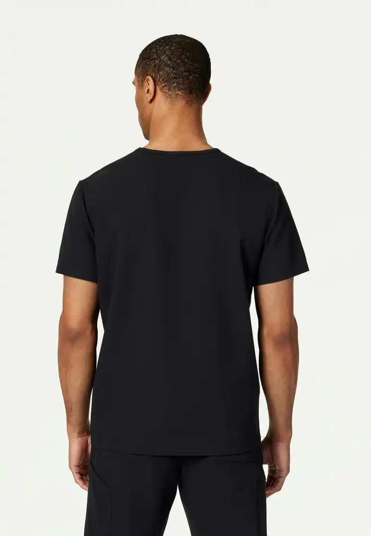 Back view of man wearing a black Jaanuu Platt scrub shirt on a white background