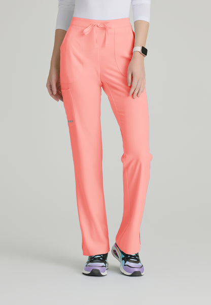 Woman wearing Skechers SK201 Coral Fizz scrub pants on a light gray background