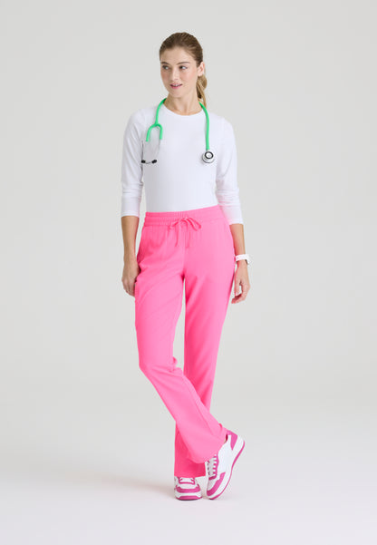 Woman wearing a white underscrub and Skechers Passion Pink SKP623 scrub pants with a green stethoscope around her neck on a light gray background
