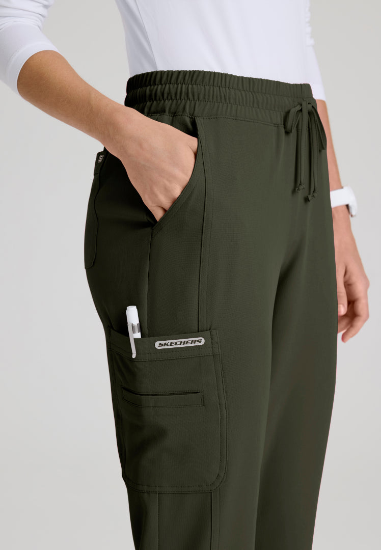 Pocket detail of a olive green Skechers SKP623 scrub pants with a visible brand logo on a white background