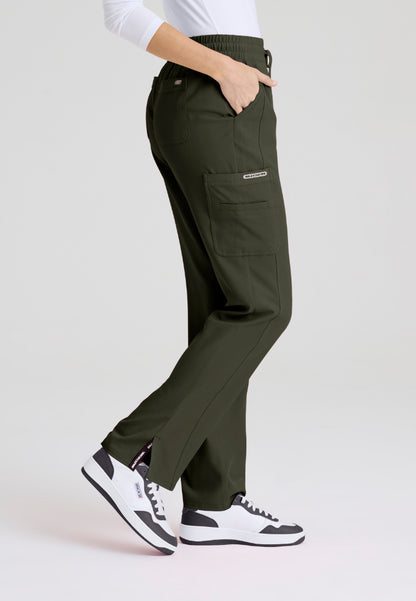 Side view of woman wearing olive green pants and white sneakers on a light gray background