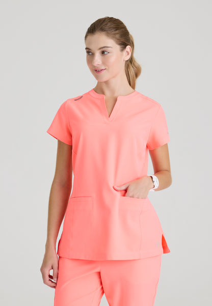 Woman wearing a Skechers SKT259 Coral Fizz scrub top on a plain background
