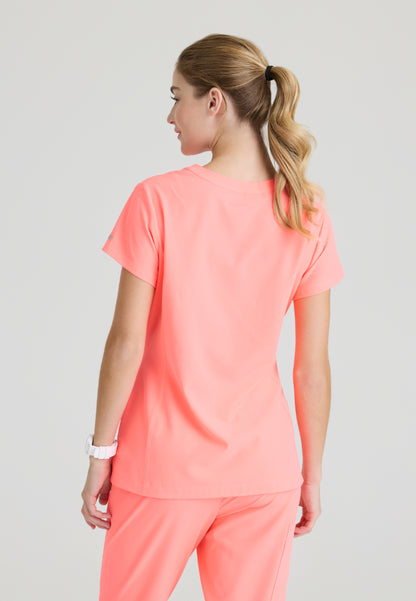 Back view of a woman wearing a Skechers SKT259 Coral Fizz scrub shirt on a plain background