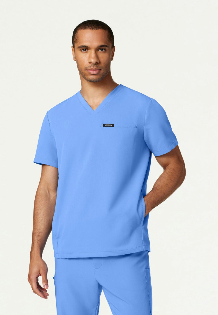 Man wearing a ciel blue Jaanuu Platt v-neck scrub shirt on a white background
