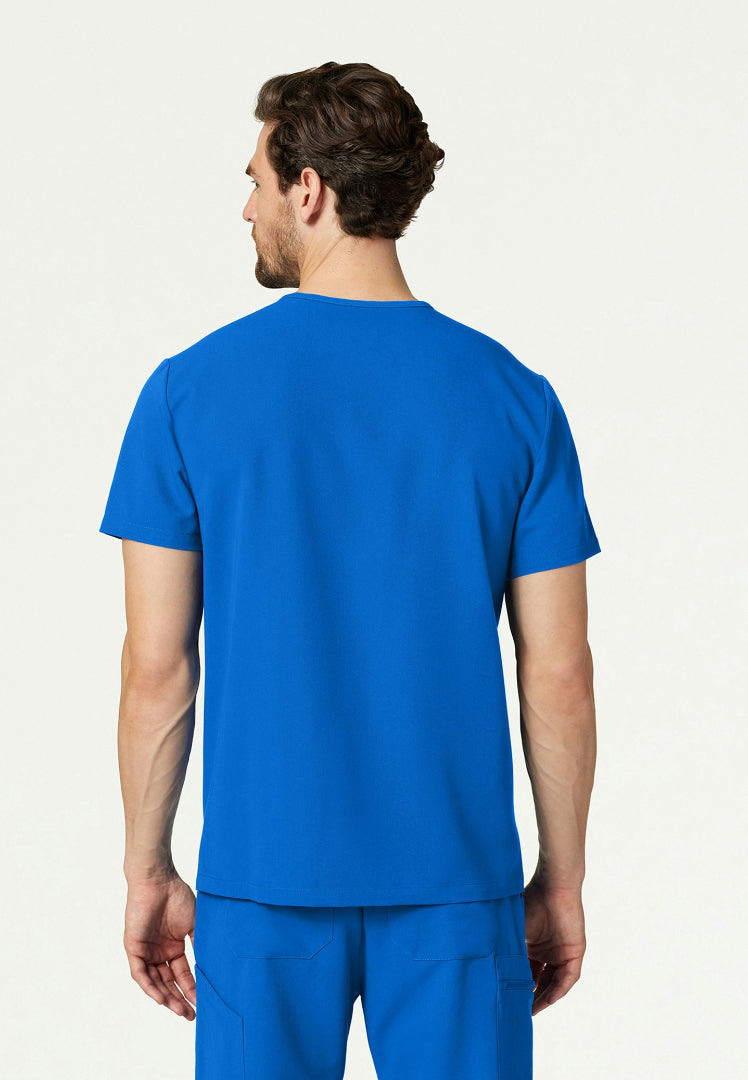 Back view of a man wearing a royal blue Jaanuu Platt scrub shirt on a white background