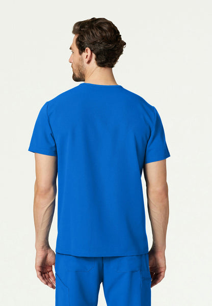 Back view of a man wearing a royal blue Jaanuu Platt scrub shirt on a white background